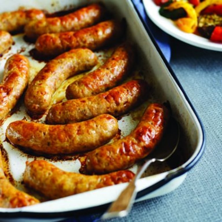 Saucisses aux légumes sur une plaque