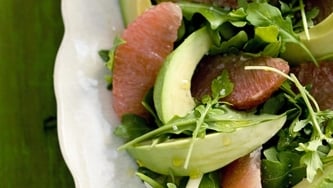 Salade d'avocat et de pamplemousse rose sur feuilles d'endive et de roquette